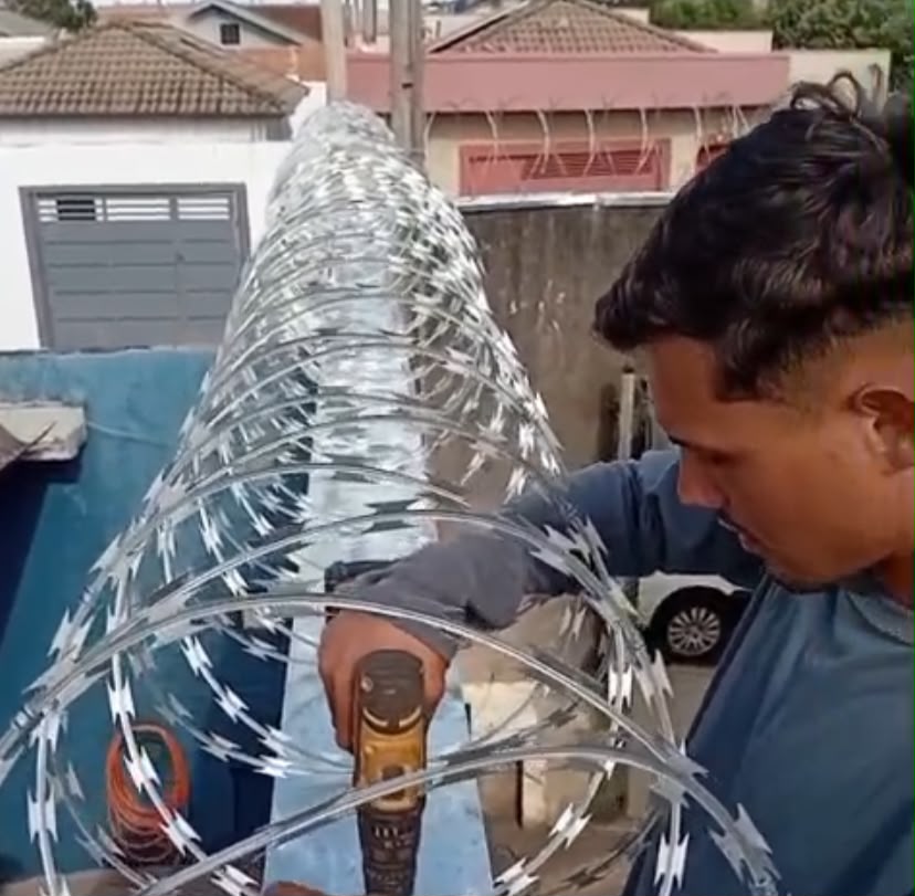 Profissional instalando concertina em muro